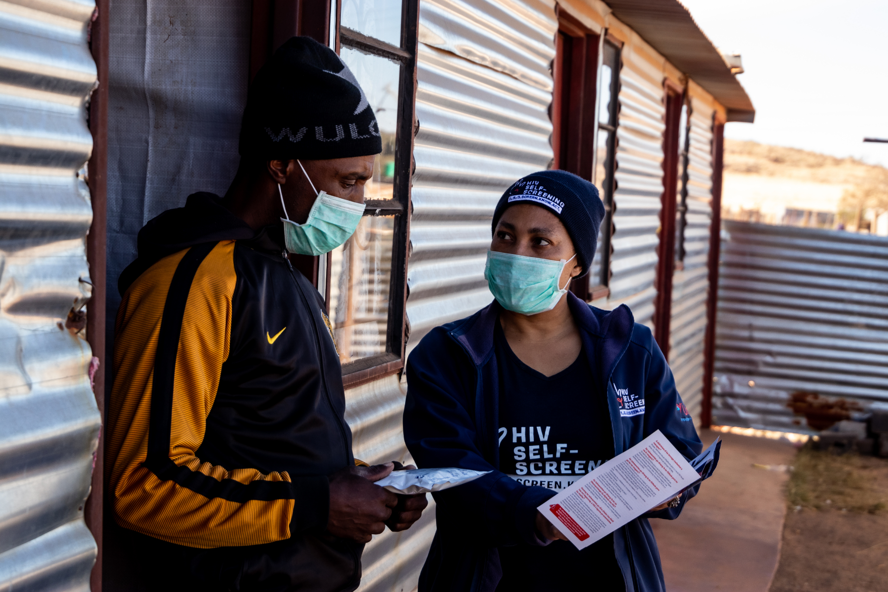 Community outreach worker sharing information while delivering an HIV self-test kit in Johannesburg, South Africa