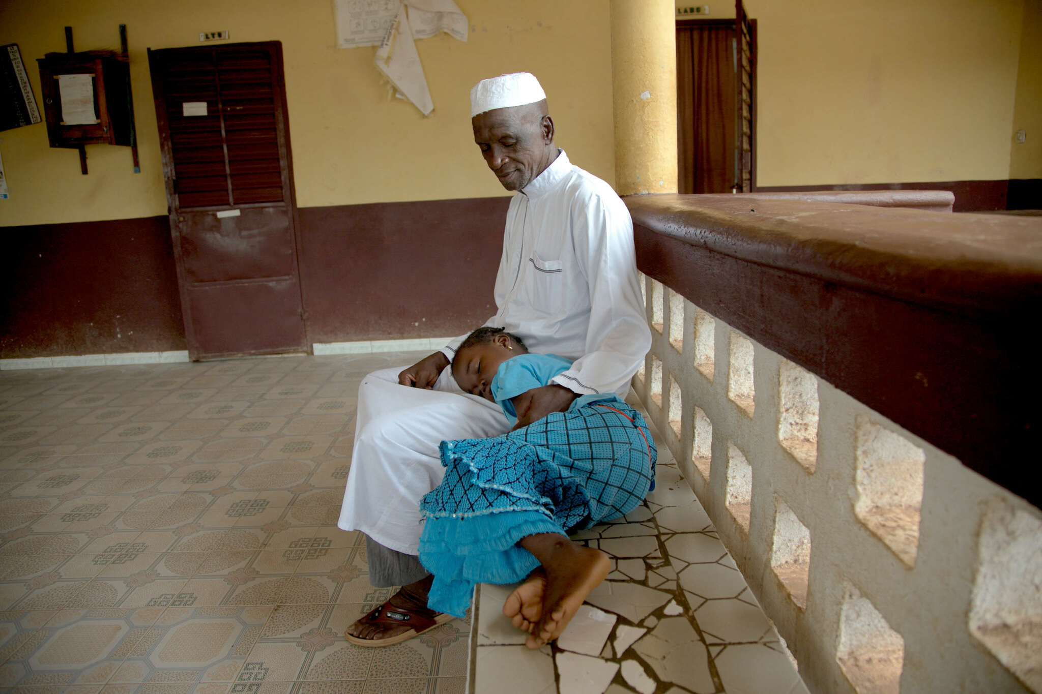 A man and his daughter at a health facility in Faranah, Guinea.