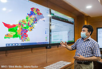 Technical officer for information management shows data on Pakistan's COVID-19 response in an operations room.